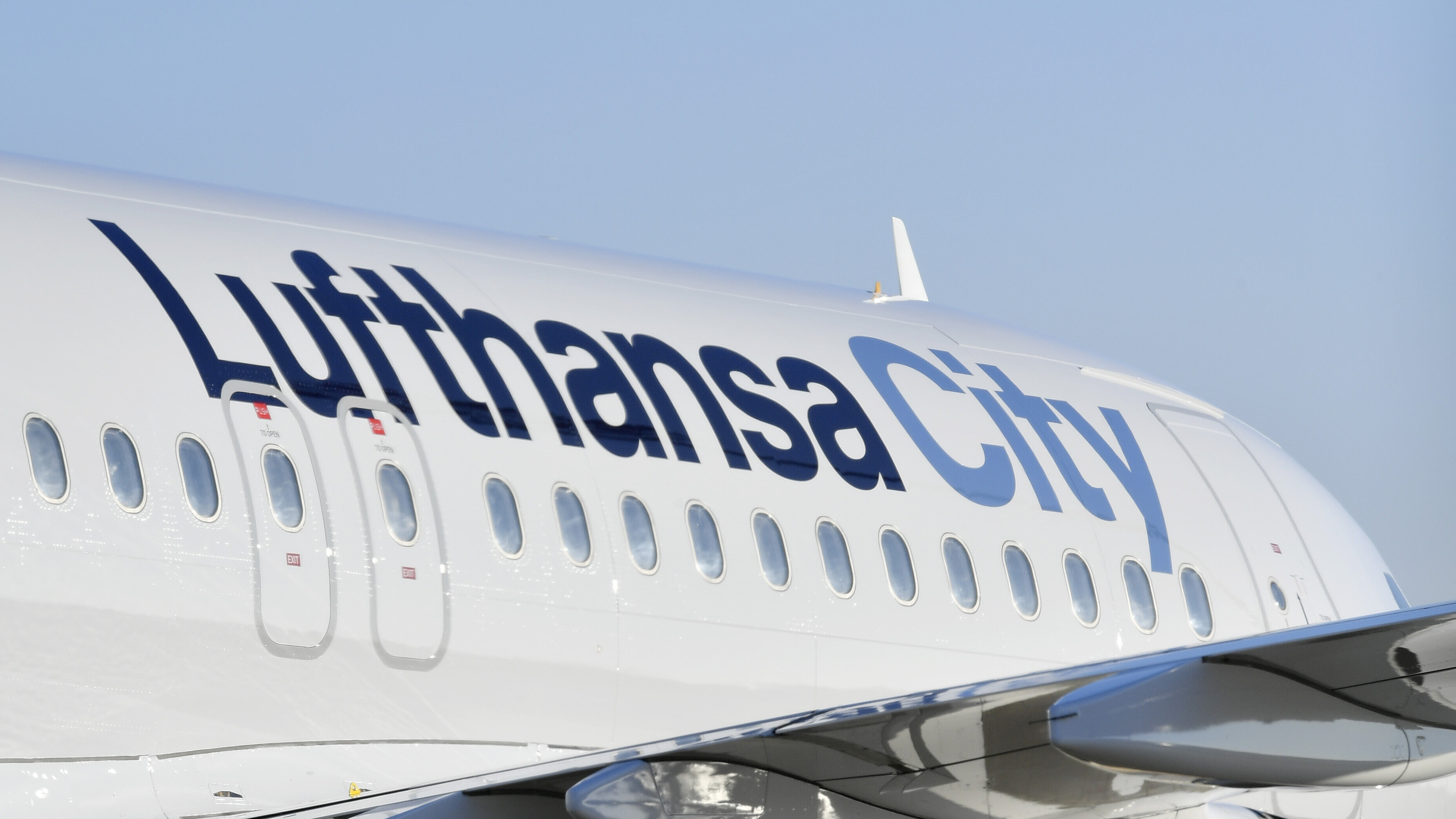 Ein schräg von hinten fotografiertes Flugzeug mit Lufthansa City Lackierung auf dem Vorfeld